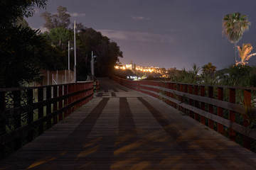 Marbella promenade at night with wood path