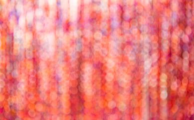 Abstract glowing lights. Orange defocused background with flashing Stars. Blurred Bokeh Curtain
