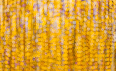 Abstract glowing lights. Gold yollow defocused background with flashing Stars. Blurred Bokeh Curtain