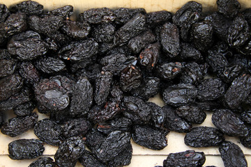 Dried plums or prunes. Dark prunes background. Dry fruit pattern.