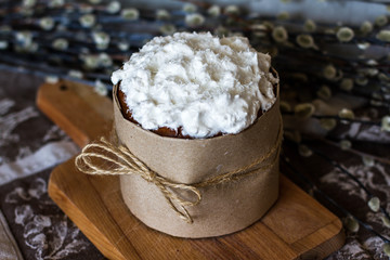 Easter cake on a dark background. Cake with white glaze. Birthday cake. Palm Sunday. Pie and willow branches. Bow of rope. Beautiful decoration. Home cake. Delicious and beautiful pastries.