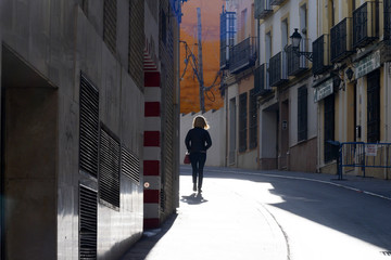 Rear view of woman walking on footpath, Antequera, Andalusia, Spain