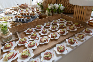 Tavolata con antipasti in contenitori bianchi