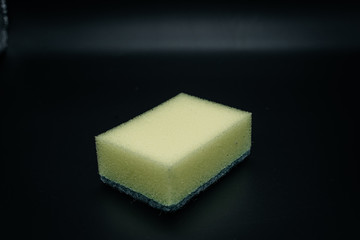 Sponge for washing dishes on a dark background close-up