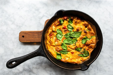 Delicious homemade omelet with vegetables cooked in oven and served in a traditional pan