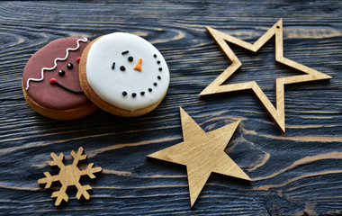 Gingerbread cookies and Christmas wooden stars on a dark wooden background. Festive background.