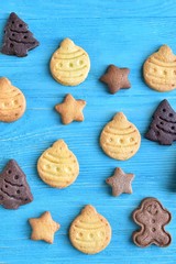 Set of cute homemade gingerbread cookies for christmas on wooden blue background. New year biscuits with beautiful iced decoration on textured turquoise backdrop. Traditional gingerbread cookies 