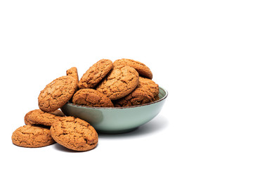 fresh tasty oatmeal cookies in a turquoise plate on a white background