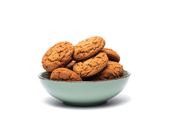 fresh tasty oatmeal cookies in a turquoise plate on a white background