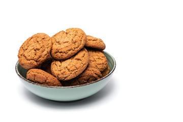 fresh tasty oatmeal cookies in a turquoise plate on a white background
