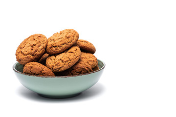 fresh tasty oatmeal cookies in a turquoise plate on a white background