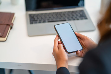 Close-up view of woman's hands holding blank screen smartphone