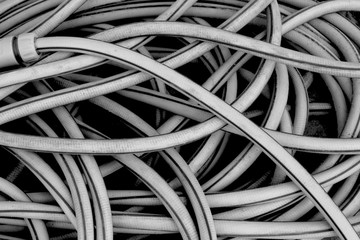 Yellow pile of a tangled long hose or cable wire background texture in black and white