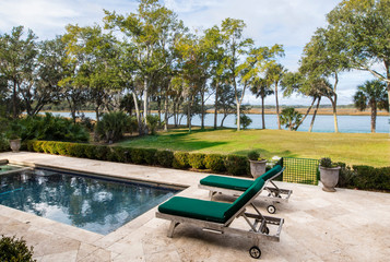 Beautiful back yard pool with view of wooded lot and river.