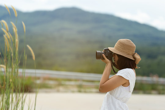 Beautiful Asian Travel Woman With Camera Sit,relax In Nature.moutain And Grass Around Herself.