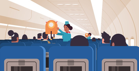 stewardess explaining for passengers how to use jacket life vest in emergency situation african american flight attendants safety demonstration concept modern airplane board interior horizontal vector