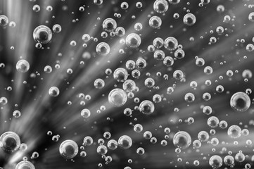 Oxygen Bubbles in Liquid. Rays. Background black and white.