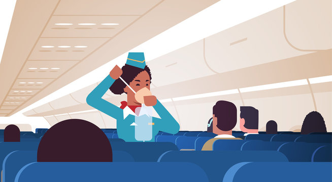 stewardess explaining for passengers how to use oxygen mask in emergency situation african american flight attendant safety demonstration concept modern airplane board interior horizontal vector