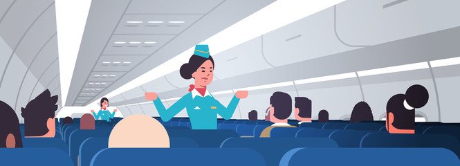 stewardess explaining instructions for passengers female flight attendants in uniform showing emergency exits safety demonstration concept airplane board interior horizontal vector illustration