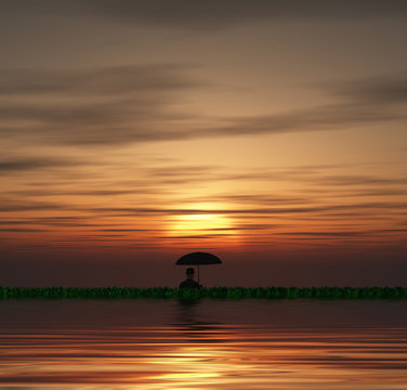 Man with umbrella in sunset or sunrise
