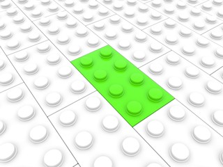 Green toy brick among white toy bricks