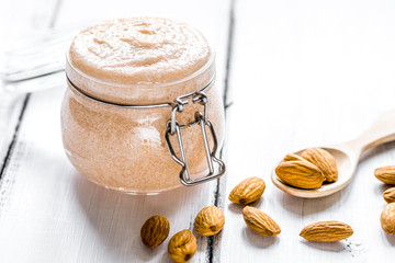 cosmetic set with almond scrub on table background
