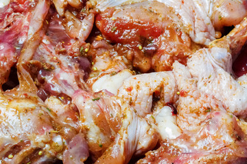 Raw marinated quails in spices with lemon in a glass saucepan. Close-up.