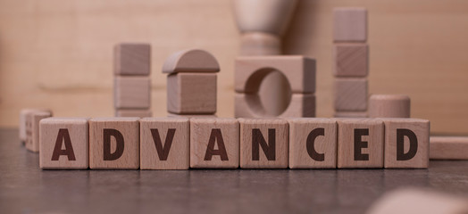 Word "Advanced" written with wooden blocks