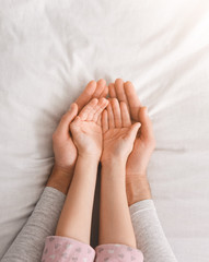 Father and daughter holding something in hands, open palms