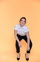 Fototapeta na wymiar Business concept. Full-length portrait of an adult pretty woman of 40 years old with good makeup in a business suit on a yellow background. Standing right in front of the camera with a smile.