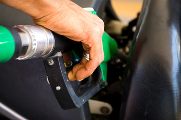Refuelling the car at a gas station fuel pump.