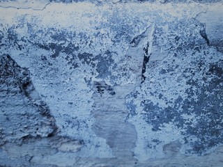 close-up of a decorative wall with bokeh effect and characteristic rough porous texture, abstract dark and light spots on a classic blue background