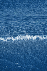 Little sea wave toned in trendy 2020 classic blue color. Sea background. Ocean wave