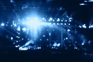 Blurred people crowd at musical concert and stage lights. Defocused background.