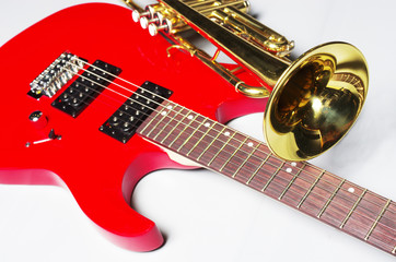 Obraz premium Electric guitar and trumpet on a light background.