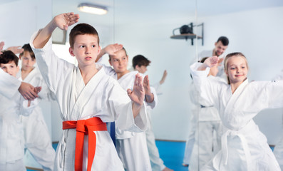 Fototapeta na wymiar Children trying martial moves in karate class