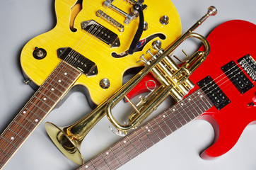 Obraz premium Two electric guitars and a pipe on a light background.