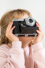Child holds nostalgia camera in hands