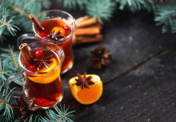 Two glasses with traditional winter or new year hot mulled wine drink with tangerines cinnamon...