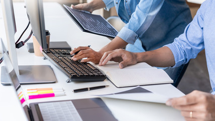 Young startup Programmers Sitting At Desks Working On Computers screen for Developing programming and coding to find solution to problem on New Application.