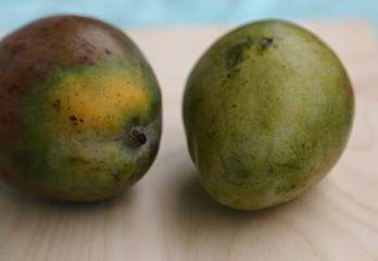 Fresh mango fruit in green peel before cooking on the table