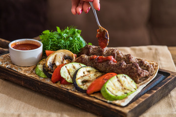 Chicken kebab with grilled vegetables on a wooden plank