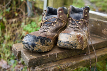 Muddy Hiking Boots in a countryside setting .