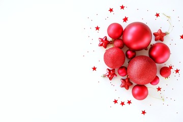 Christmas flat lay background from red balls decorations on a white background. Creative minimalistic holiday concept. Top view with copy space.