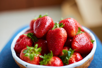 woman holding a bowl of freshly red strawberries