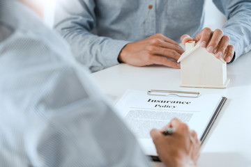 broker agent and customer holding pen, the policyholder and explain discussing for concerning mortgage loan offer for and house insurance.
