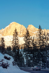 Car driving under the mountain Catinaccio - Rosengarten, Dolomites, South Tyrol, Italy