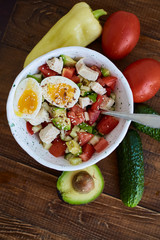 Summer salad with fresh vegetables, avocado and eggs