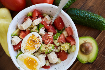 Summer salad with fresh vegetables, avocado and eggs