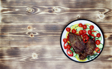 Baked pork neck with fresh vegetables - cucumbers, peppers, cherry tomatoes